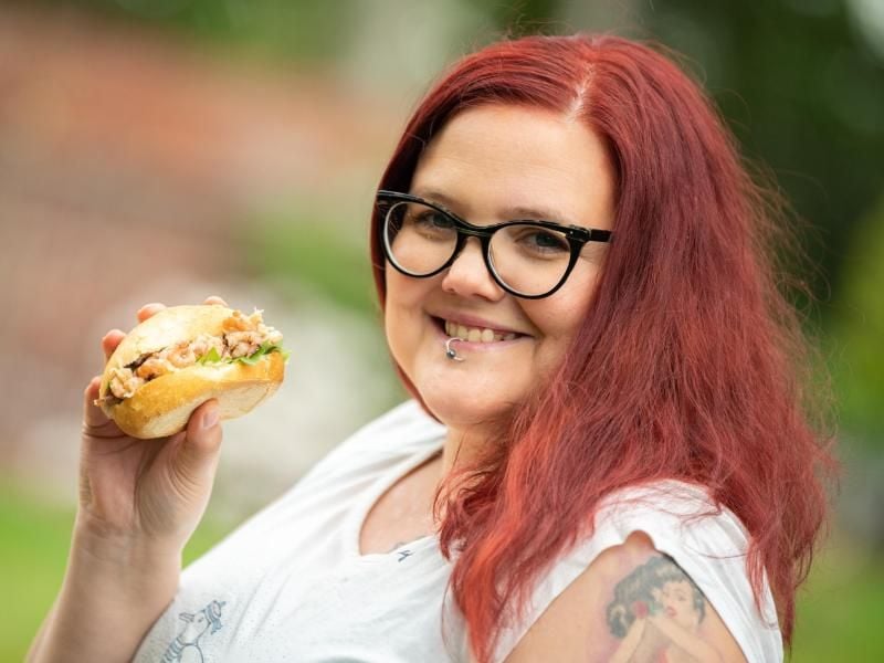 Christin Klever hält ein Krabbenbrötchen in der Hand. Foto: Mohssen Assaninmoghaddam/dpa