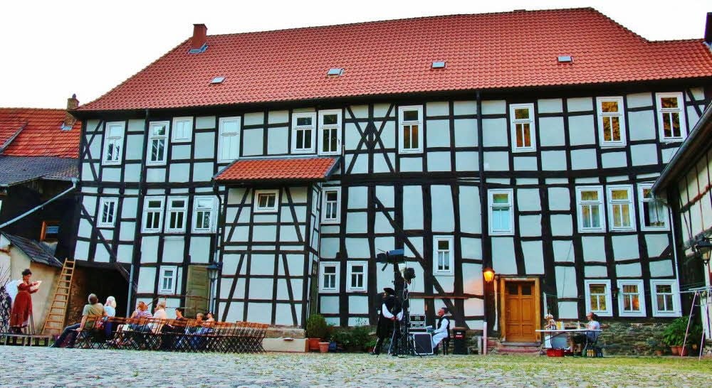 Auf der straßenabgewandten Seite zeigt der Jägerhof seine strahlende Fachwerkfassade, hier bei der Aufführung eines Theaterstücks.
