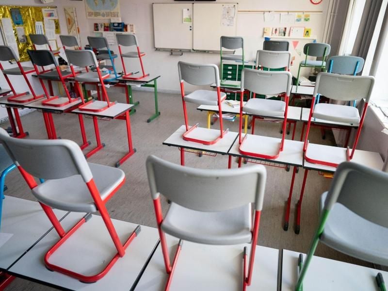 Stühle stehen in einer Schule auf den Tischen. Foto: Kay Nietfeld/dpa/Archivbild