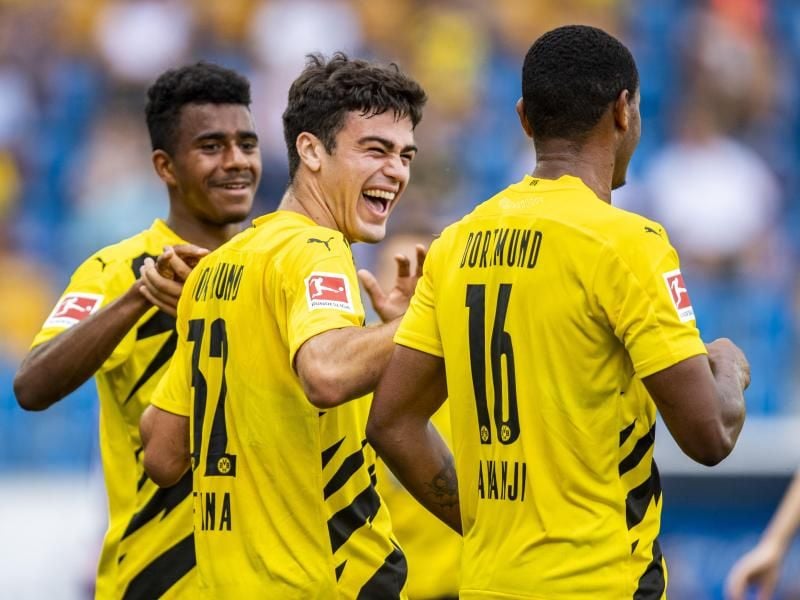 Die Dortmunder Ansgar Knauff, Giovanni Reyna und Manuel Akanji (l-r) jubeln nach einem Treffer im Testspiel. Foto: David Inderlied/dpa