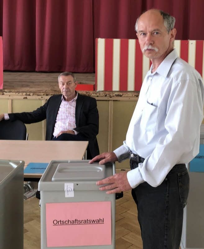 Wahlvorsteher Jürgen Kristin an einer der fünf Wahlurnen, die am Sonntag in Söllichau aufgestellt waren. Im Hintergrund Reinhard Domtera, der zum Team der Wahlhelfer gehört.