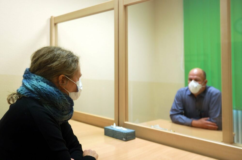 Getrennt durch eine Scheibe können sich Gefangene derzeit mit ihren Angehören treffen. Mundschutz ist Pflicht, Anfassen verboten.