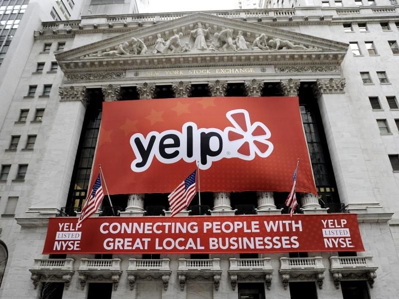 Ein Banner mit dem Logo des Bewertungsportals Yelp hängt am Gebäude des New York Stock Exchange in New York. Foto: Justin Lane/EPA/Archiv