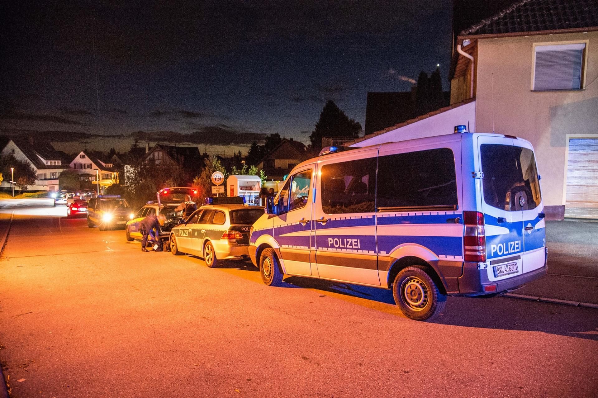 Polizeifahrzeuge stehen in Villingendorf auf einer Straße in dem Wohngebiet, in dem drei Menschen erschossen wurden.