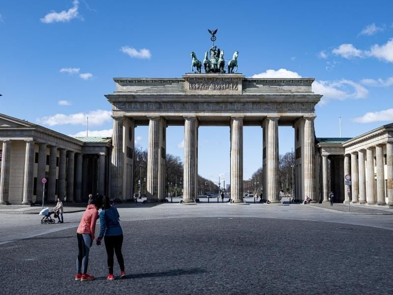 Zwei Joggerinnen machen auf dem sonst gut besuchten Pariser Platz vor dem Brandenburger Tor in Berlin ein Selfie. Foto: Fabian Sommer/dpa