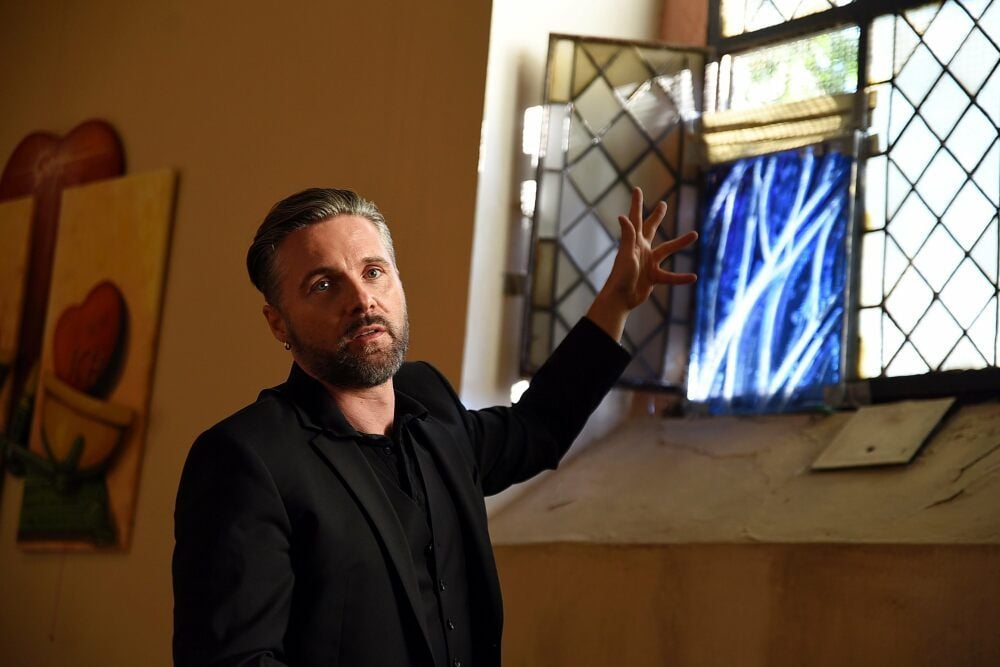 Der Künstler Christian Keinstar zeigt eine Musterscheibe der späteren Kirchenfenster und erklärt seine Idee dahinter.