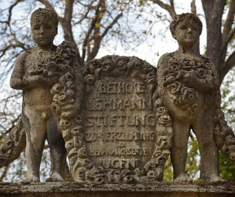Zwei Knaben zieren mit einem Spruch den Brunnen.