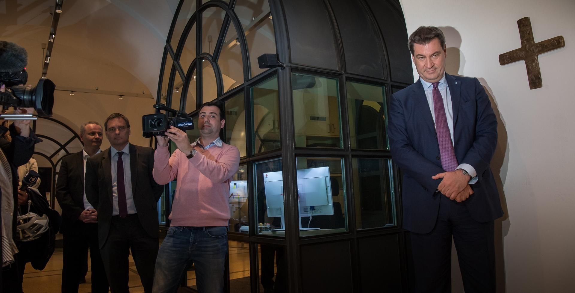Ein Kreuz hängt neben dem bayerischen Ministerpräsidenten Markus Söder.