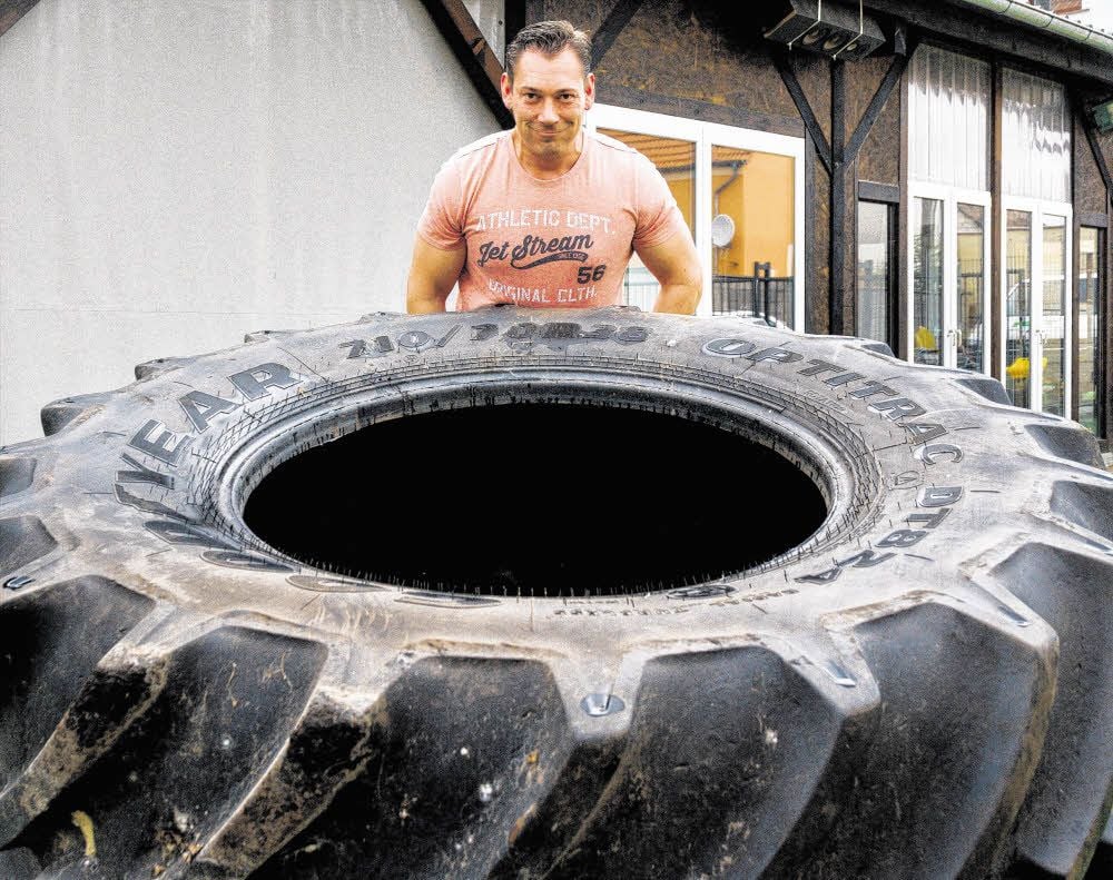 Beim Strong-Man-Wettkampf am Sonnabend in Wünsch ist eine Disziplin, einen 275 Kilo schweren Reifen mehrfach umzuwerfen. Lokalmatador Roman Schmidt macht es hier vor.