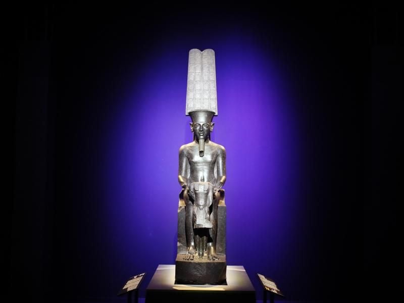 Die Statue „Der Gott Amun beschützt Tutanchamun” wird im Rahmen der Ausstellung „Tutanchamun, der Schatz des Pharaos” in der Grande Halle de La Villette gezeigt. Foto: Francois Mori/AP