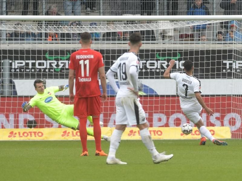 Sandhausens Andrew Wooten (r) verlädt Heidenheim-Keeper Kevin Müller. Foto: Stefan Puchner