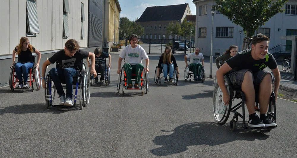 Es gilt, im Rollstuhl eine kleine Steigung zu nehmen.
