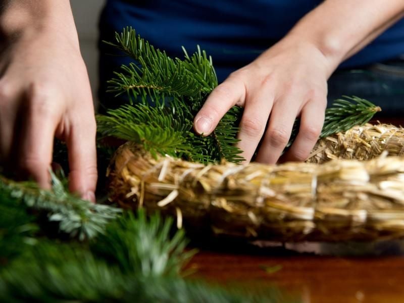 Gar nicht so aufwendig wie gedacht: Ein Adventskranz lässt sich recht schnell binden. Und das Grün der Zweige ist gerade die Trendfarbe für den Advent 2018. Foto: Franziska Gabbert