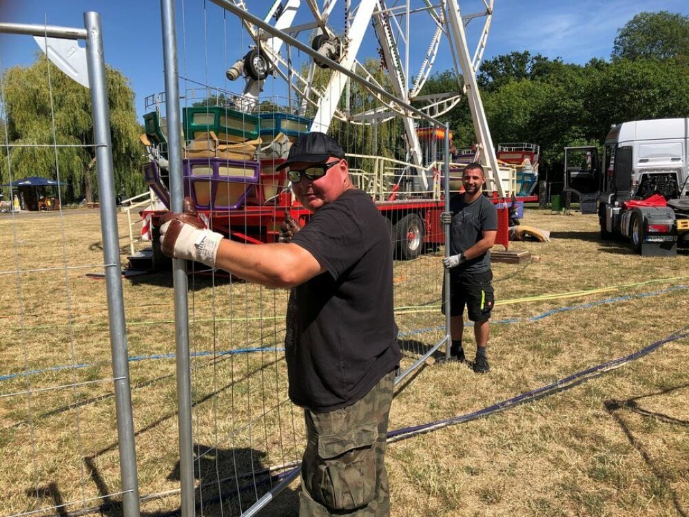 Andrzej Krzywicki (l.) und Miachel Klemm bauen den Zaun an der Fontäne auf.