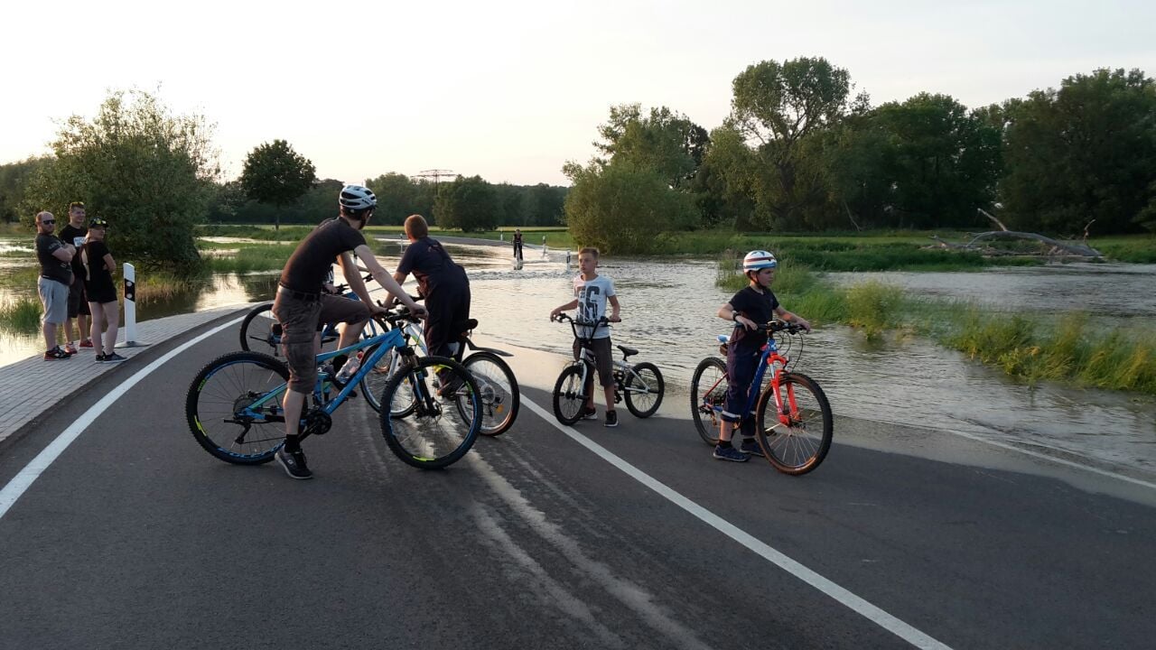 Die Straße zwischen Reuden und Ostrau steht am Freitagabend unter Wasser. Die Überflutung zieht Schaulustige an. Die Straße war bereits beim Jahrhunderthochwasser 2013 beschädigt worden. Nach erfolgtem Neubau ist sie erst 2018 wieder eingeweiht worden.