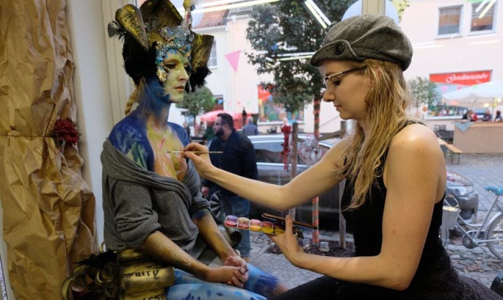Bodypainterin Julie Böhm (rechts) aus Wittenberg verwandelt Model „Knusperflocke“ im „Tintenfass“ in ein kleines Kunstwerk.
