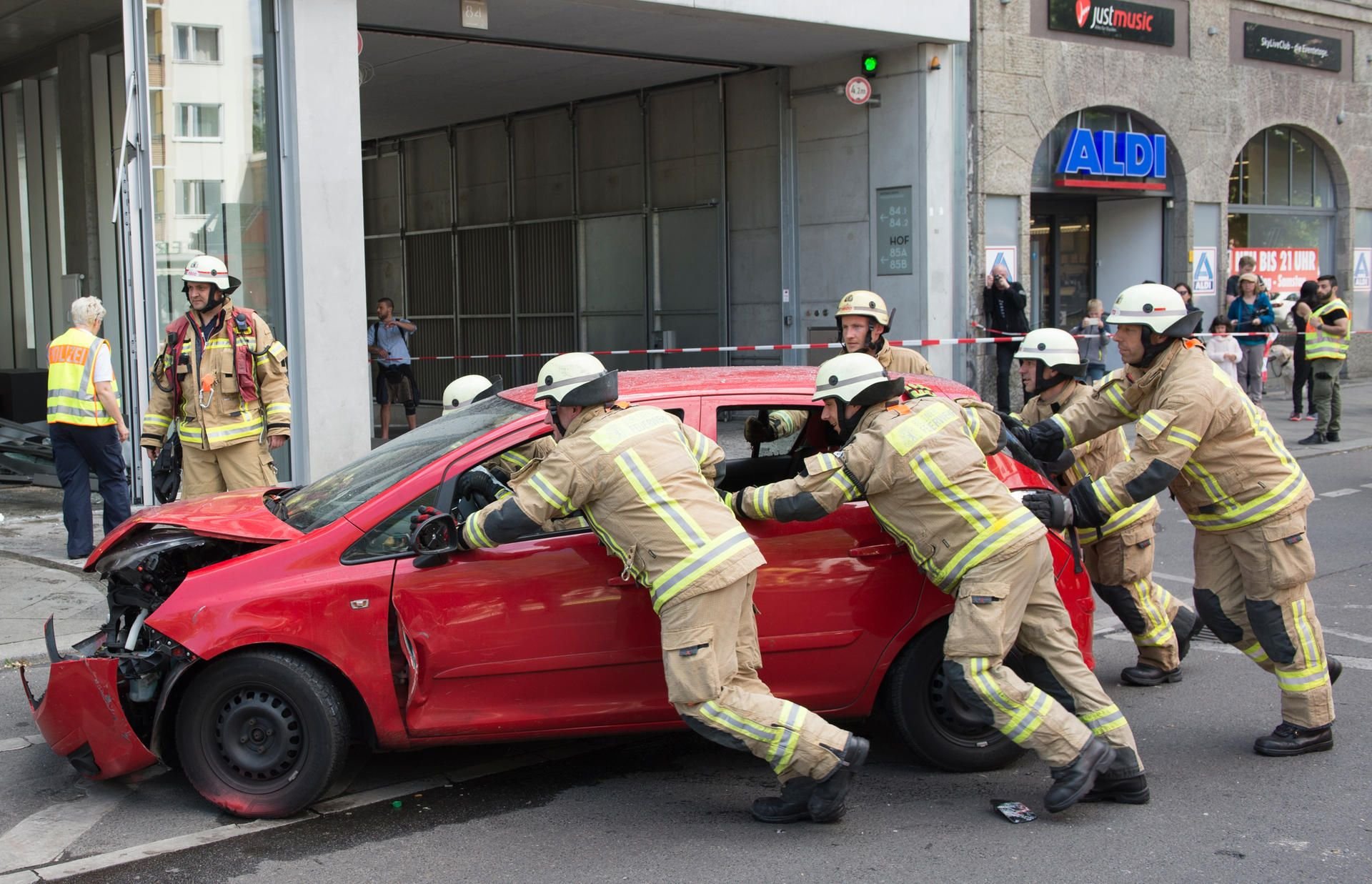 Feuerwehrleute schieben am 10. Juni 2017 in Berlin einen Pkw auf den Gehweg.