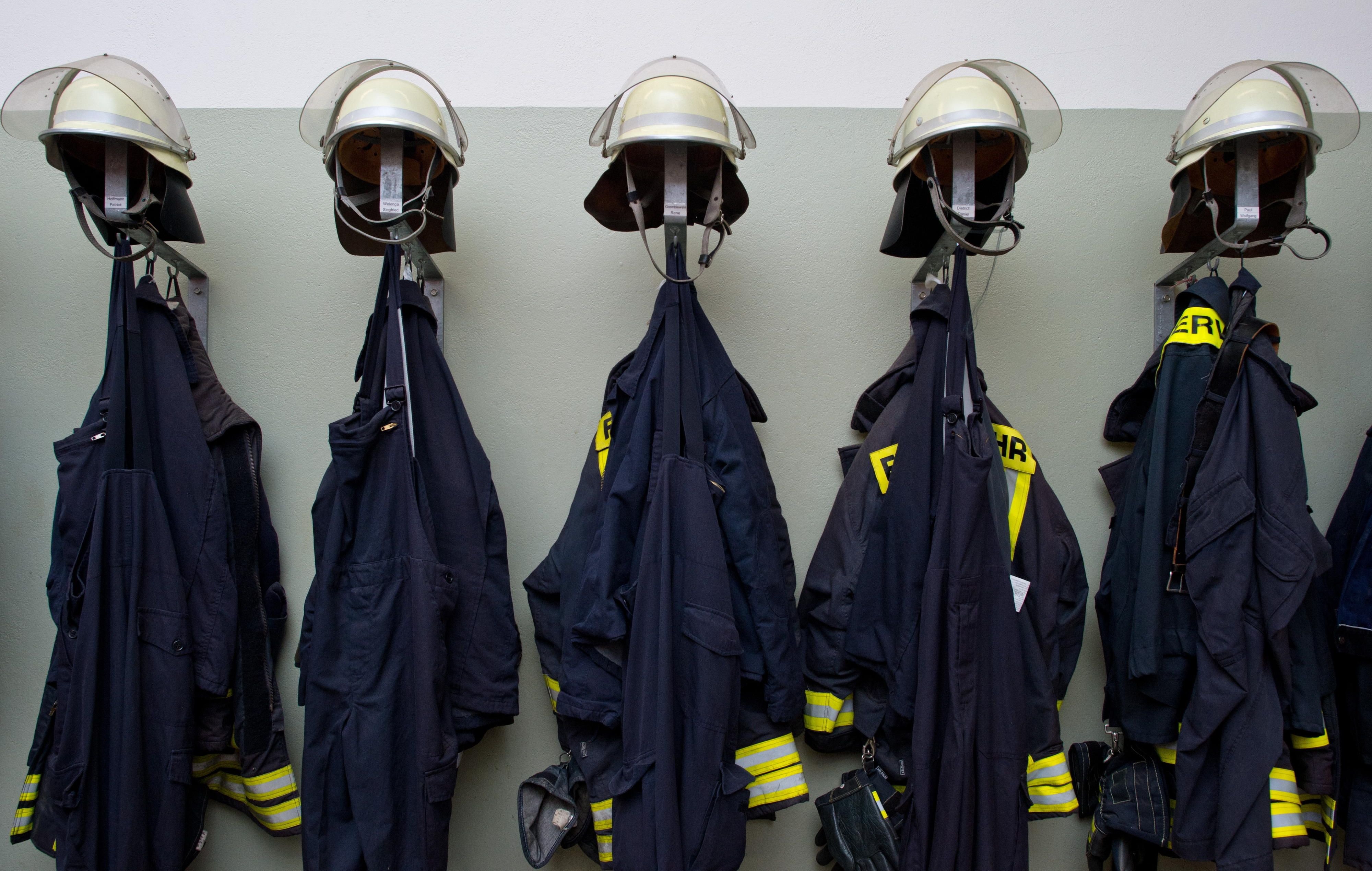 Uniformen hängen im Umkleideraum einer Feuerwehr.