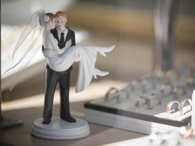 Hochzeitspaar-Figuren stehen in der Auslage eines Juweliers. Foto: Friso Gentsch/dpa/Symbolbild