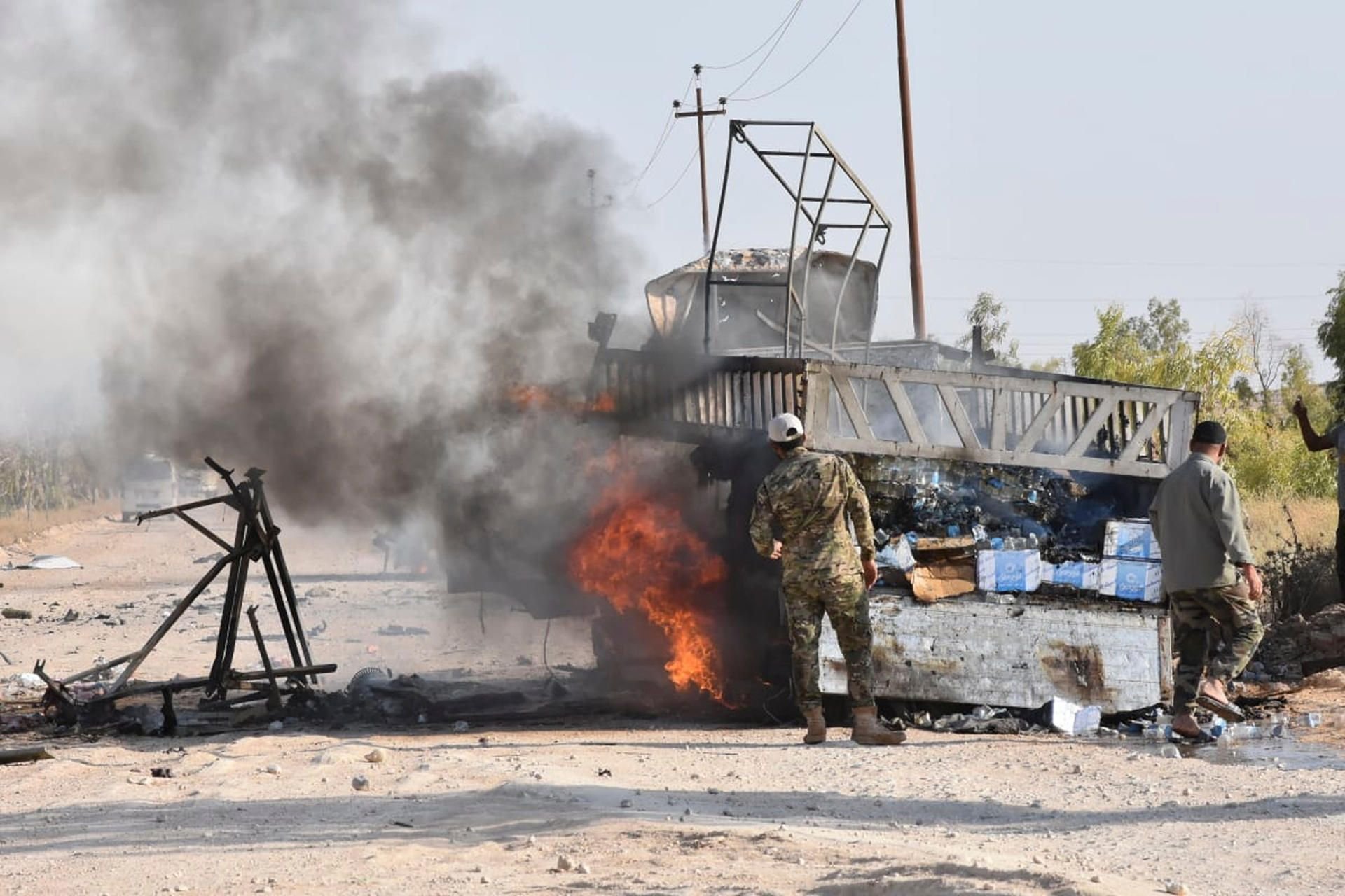Soldaten stehen am 25. August nach einem möglichen Drohnenangriff in der Provinz Anbar neben einem brennenden Fahrzeug.