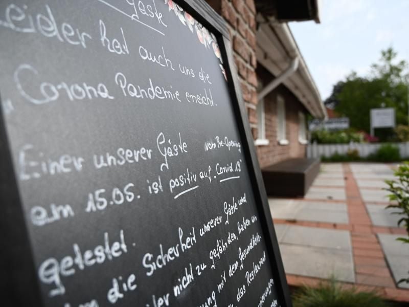 Ein Schild mit der Aufschrift „Leider hat auch uns die Corona Pandemie erreicht”, steht vor dem Restaurant „Alte Scheune” in Moormerland. Foto: Lars-Josef Klemmer/dpa
