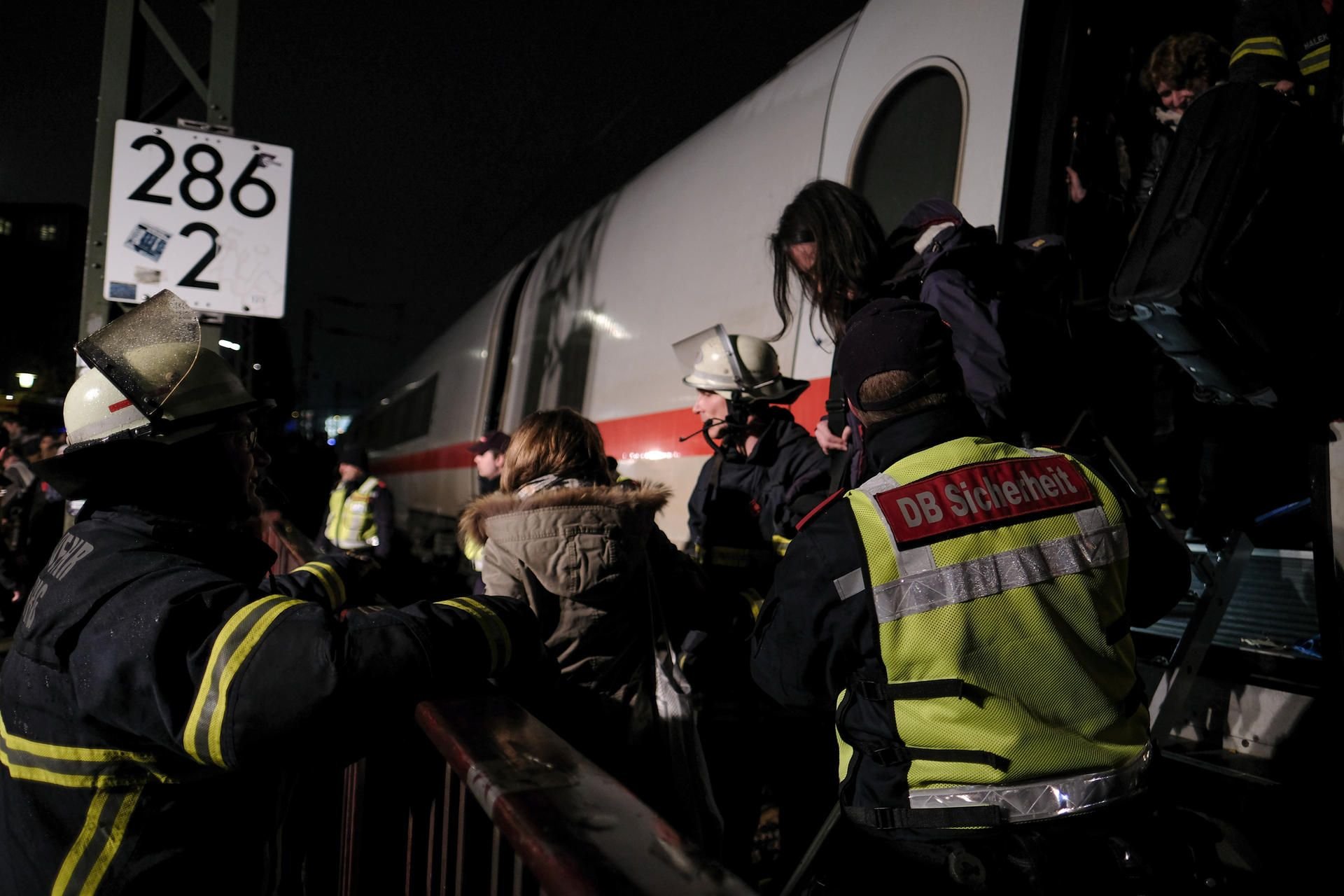 Feuerwehrleute und Mitarbeiter der DB-Sicherheit helfen in Hamburg Bahnreisenden aus einem ICE.