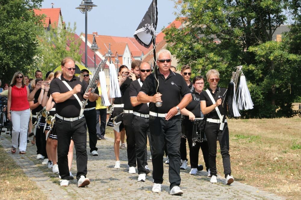 Die Spielleutegemeinschaft „Schwarze Elstern“ zieht am Sonntag spontan über die Jessener Fußgängerbrücke in Richtung Festplatz.