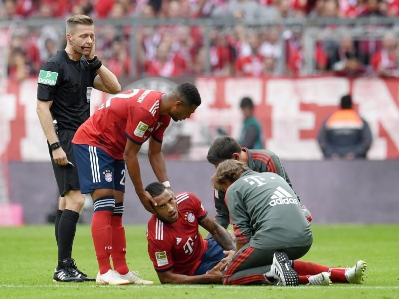 Bayerns Corentin Tolisso (M, liegend) wird behandelt und im Anschluss verletztungsbedingt ausgewechselt. Foto: Tobias Hase