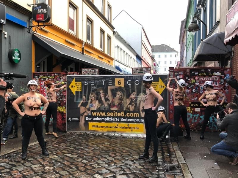 Mit nacktem Oberkörper und einer Flex demontieren Aktivistinnen im Rotlichtviertel von St. Pauli einen Sichtschutz der Herbertstraße. Foto: Carina Lue