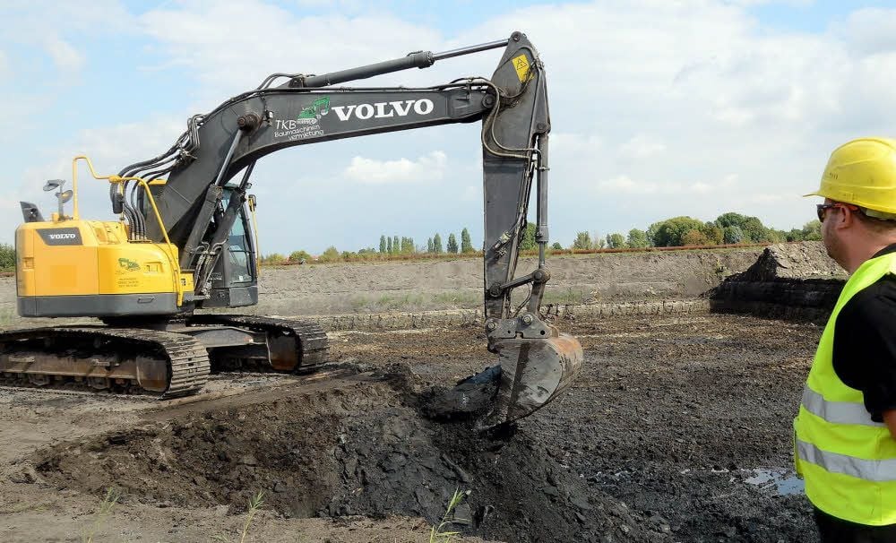 Die getrocknete Asche, die im Tagebaurestloch Luckenau Süd-Ost lagert, wird abgebaggert und als Füllmaterial verwendet.