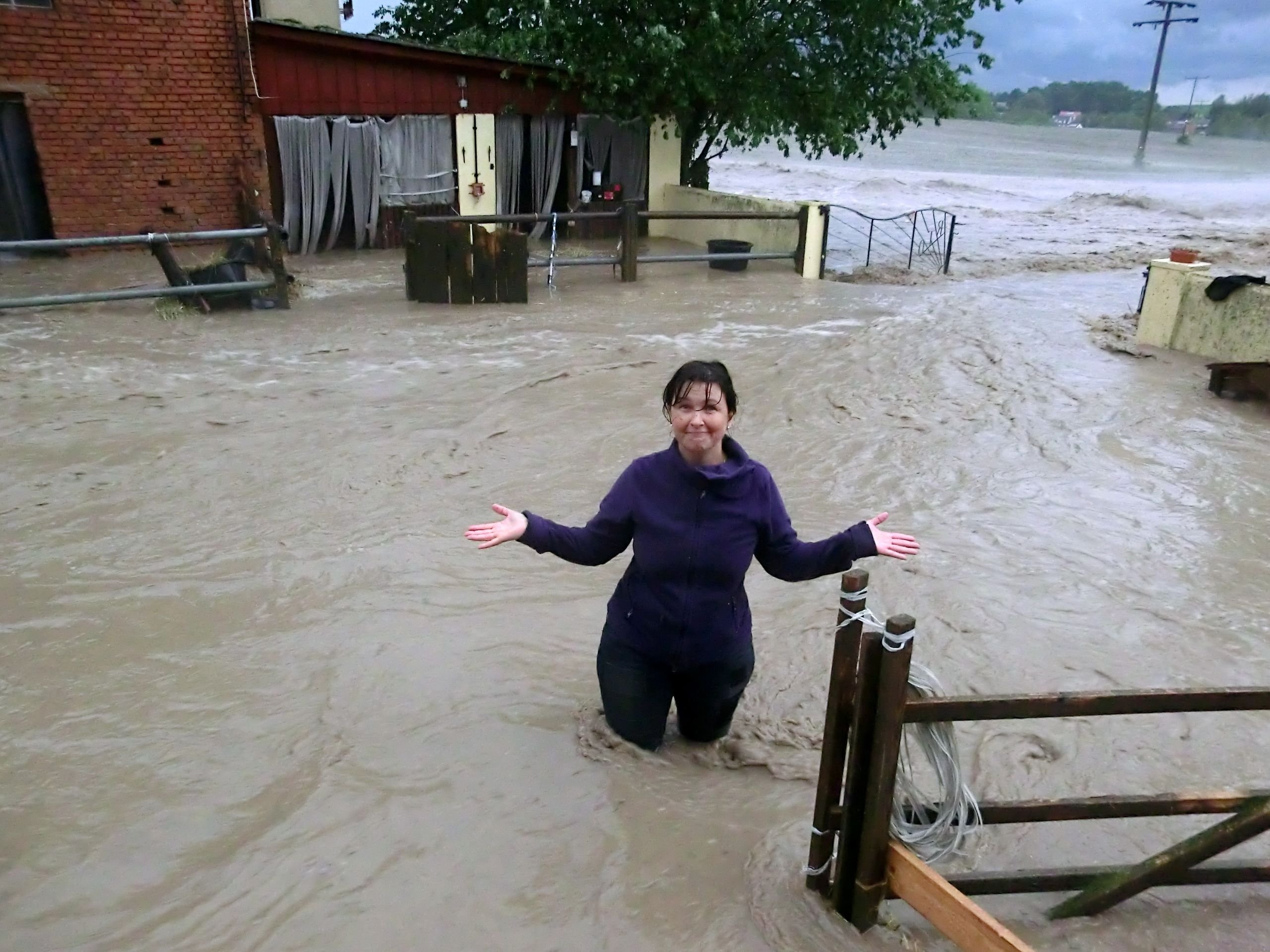 Eine Frau steht am 29.05.2016 an einem Pferdehof im mittelfränkischen Obernzenn (Bayern) nach einem Unwetter im hüfthohen Wasser.