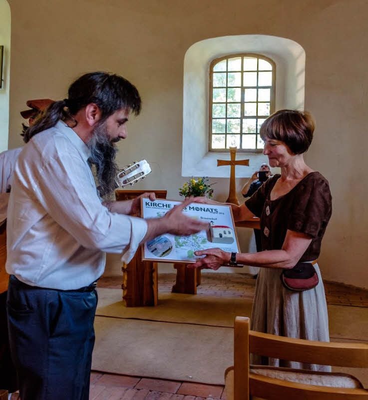 Lysander Pötzsch überreicht die Urkunde zur Kirche des Monats.