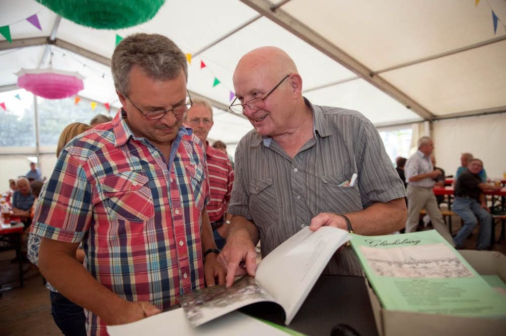 Schon vor Beginn der Lesung zeigten Einwohner von Linda, hier Roland Otter (links), großes Interesse am Buch von Dr. Reinhard Stolze.