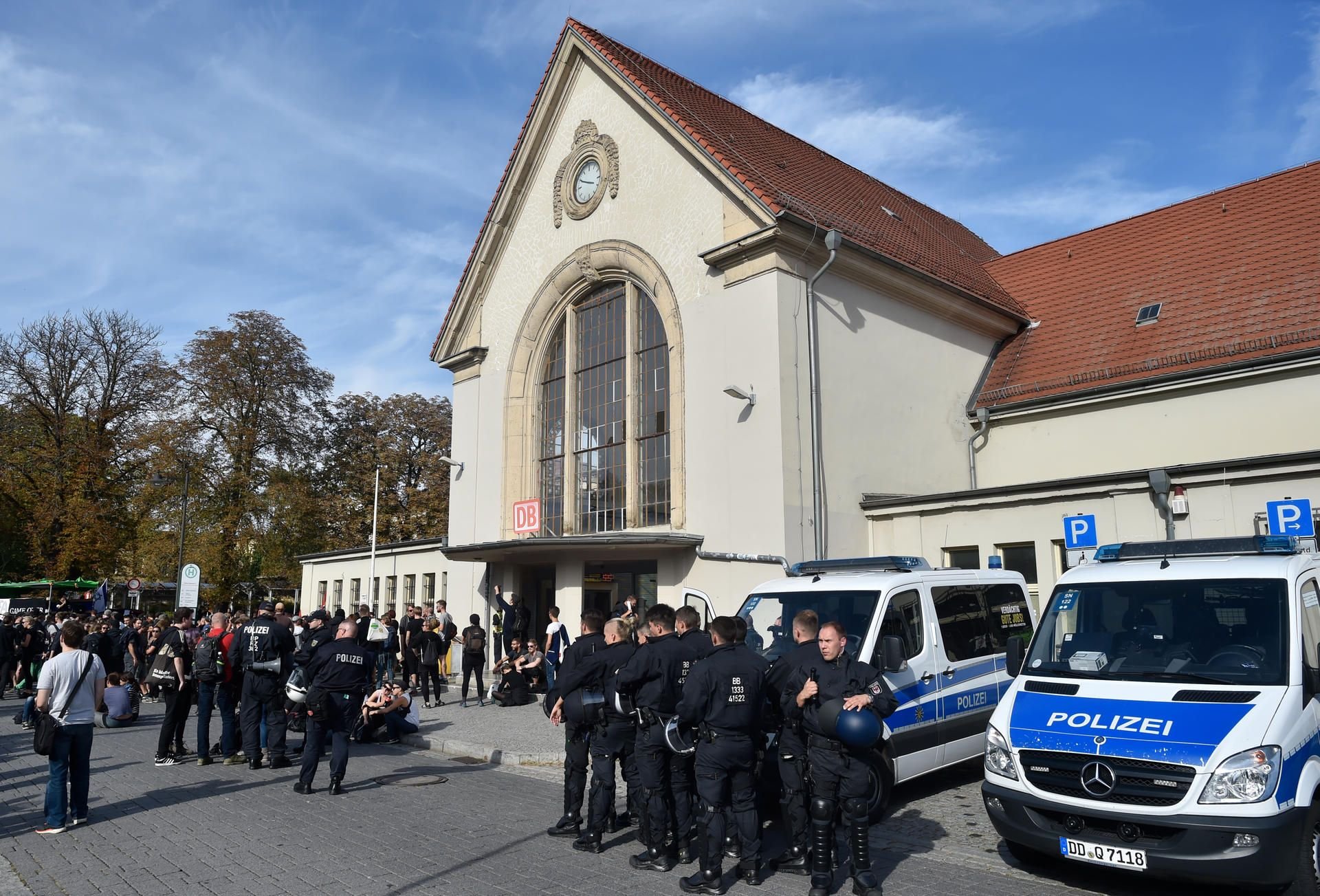 Teilnehmer der Kundgebung "Der extremen Rechten entgegentreten" und Polizisten versammeln sich am Bahnhof.