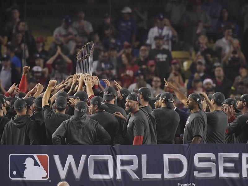 Die Spieler der Boston Red Sox jubeln über ihren Sieg mit der Trophäe. Foto: Mark J. Terrill/AP