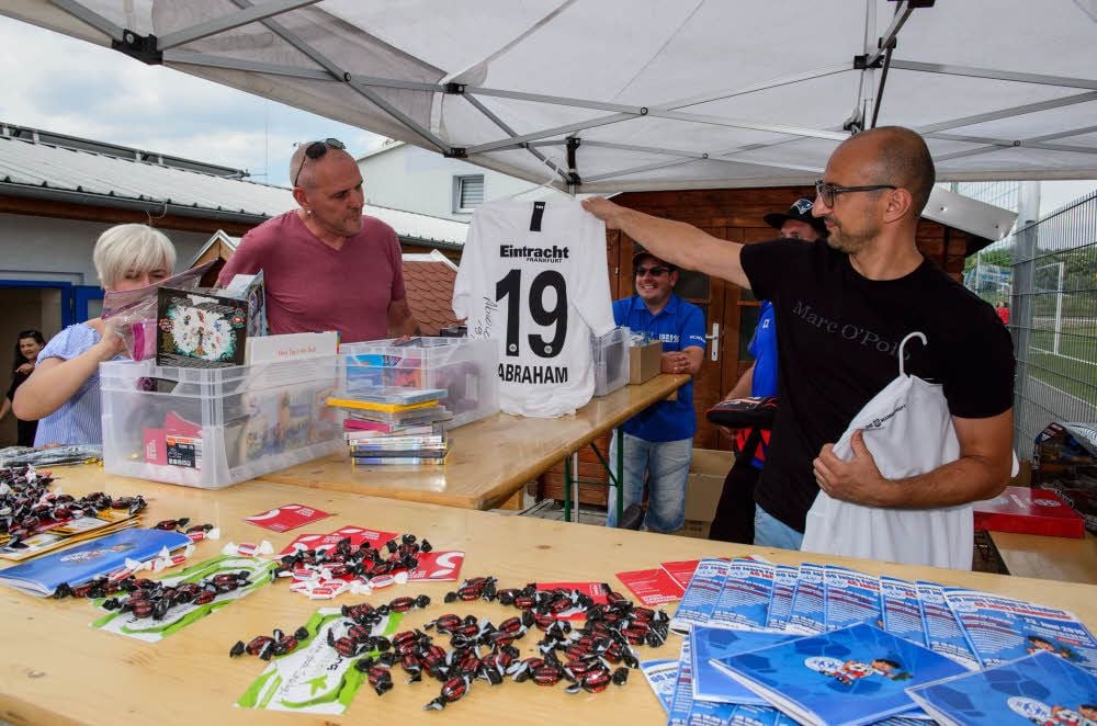ESM-Chef Torsten Menzel (r.) präsentiert einen der attraktiven Tombola-Preise: ein handsigniertes Trikot von Eintracht-Frankfurt-Kapitän David Abraham.
