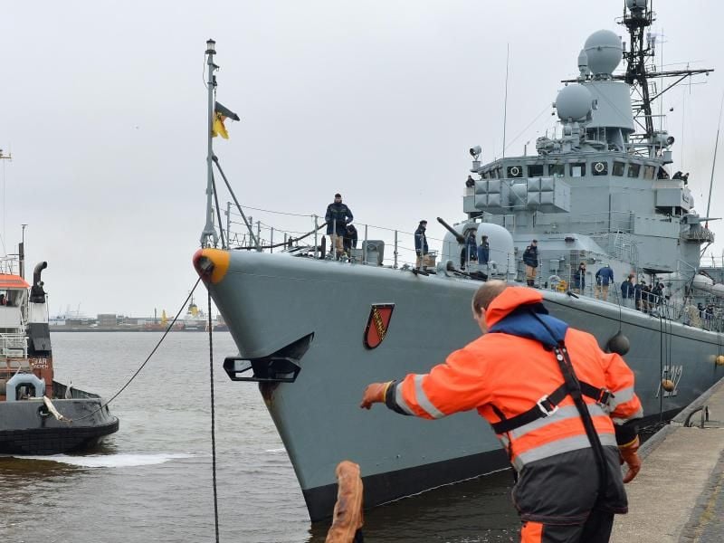 Ein Mann löst in Wilhelmshaven die Leinen der Fregatte „Karlsruhe”. Foto: Carmen Jaspersen/Archiv