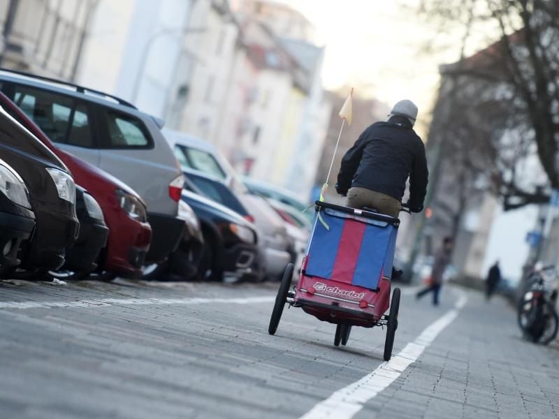 Eltern sollten bei Fahrradanhängern darauf achten, dass sie im Verkehr gut sichtbar sind. Foto: Tobias Hase/dpa-tmn