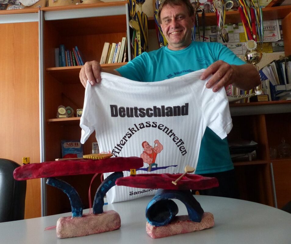 Vereinschef Lutz Wilke mit dem aktuellen T-Shirt und den beiden Wanderpokalen