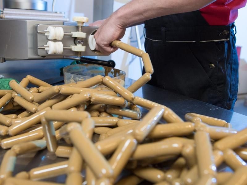 Ein Fleischer-Facharbeiter bedient eine Wurstmaschine. Foto: Sebastian Kahnert/dpa-Zentralbild/dpa/Archivbild