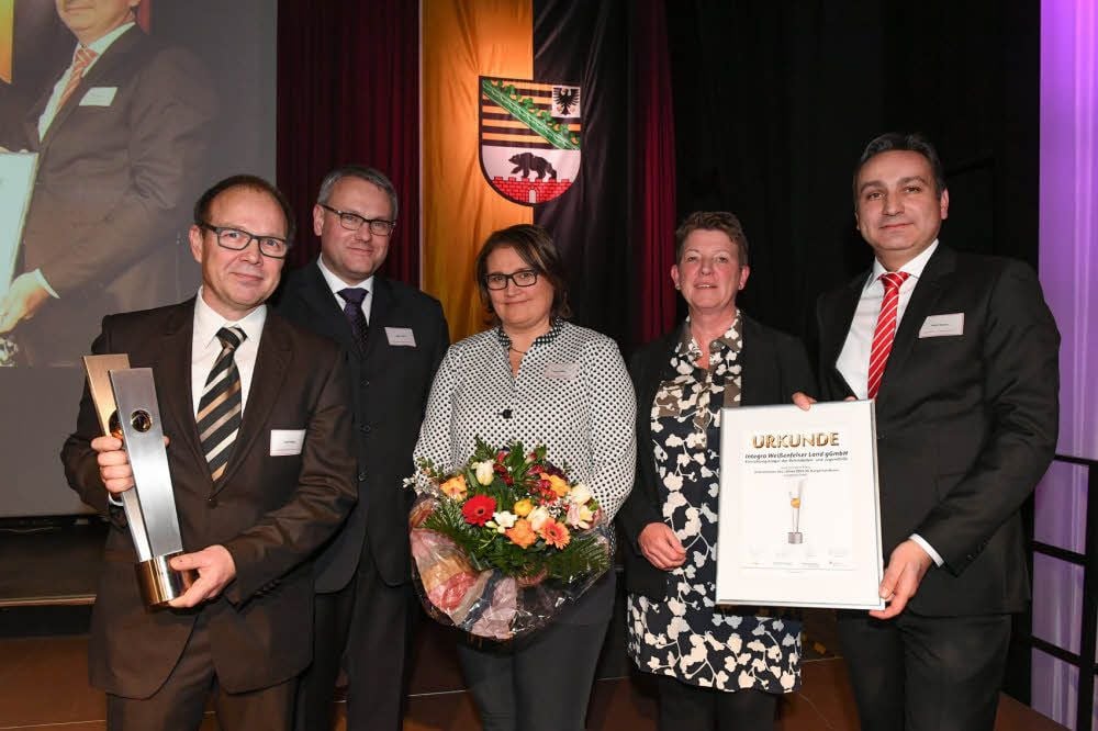 Geschäftsführer Ralf Müller (l.) und Anette Müller (3.v.l.) nehmen von Mario Kerner (r.) für die Integra Weißenfelser Land den Unternehmerpreis entgegen.