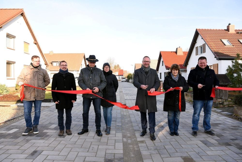 Mit dem durchschnittenen roten Band ist es offiziell: Die beim Hochwasser überschwemmte Amselwaldsiedlung in Aken ist nicht mehr Baustelle.