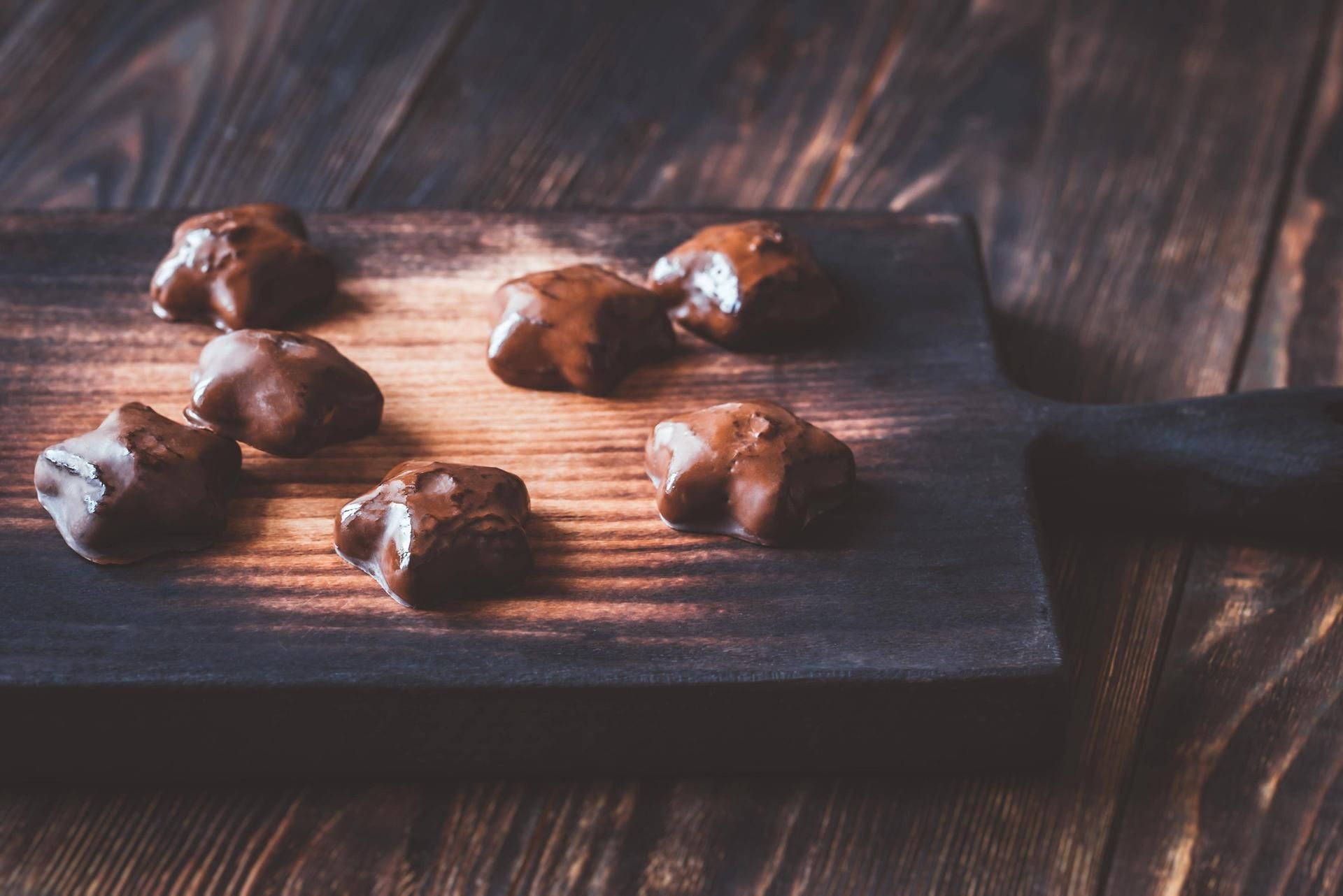 Frisch gebackene Lebkuchen liegen auf einem Holzbrett.