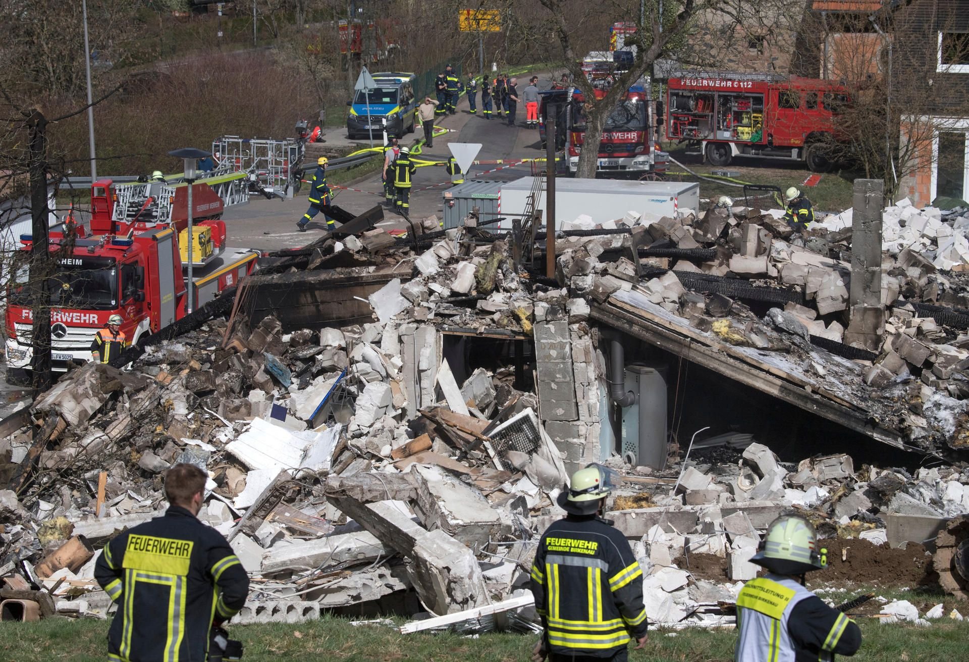 Rettungskräfte von Feuerwehr und technischem Hlfswerk (THW) stehen am Freitag vor den Trümmern eines Wohnhauses in einem Ortsteil von Birkenau in Südhessen.