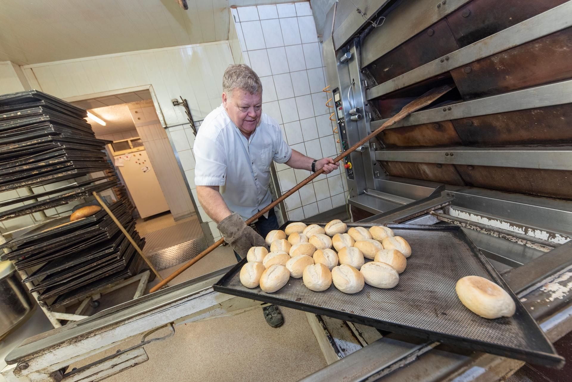 Bäckermeister Ulrich Hecht holt zum letzten Mal Brötchen aus dem Backofen seiner Bäckerei in Gernrode.