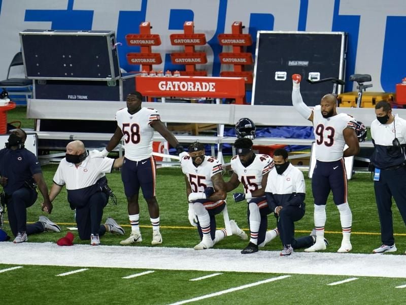 Die Spieler der Chicago Bears knien während der Nationalhymne in Solidarität mit der „Black Lives Matter”-Bewegung vor dem Spiel nieder. Foto: Paul Sancya/AP/dpa