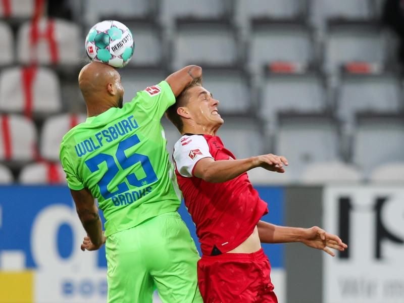 Wolfsburgs John Anthony Brooks (l) kommt vor Freiburgs Nils Petersen an den Ball. Foto: Tom Weller/dpa