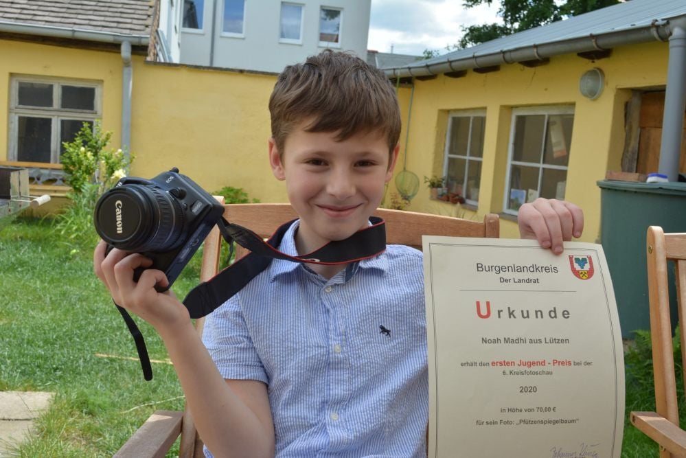 Noah Madhi mit dem Fotoapparat seiner Mutter und der Siegerurkunde für den ersten Jugendpreis