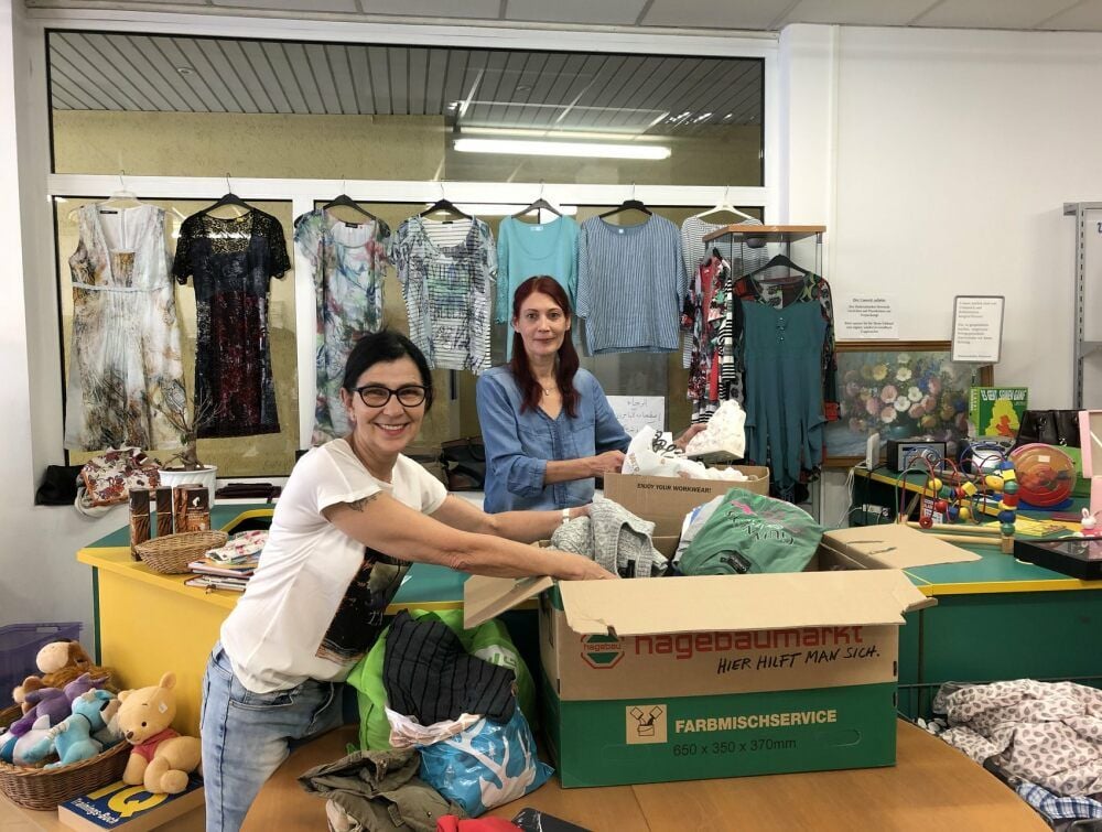 Martina Krause und Manuela Hoffmann (v.li.) packen im Diakonieladen in Hettstedt Kisten mit Spenden aus.
