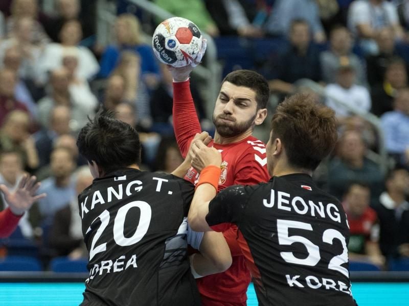 Serbiens Vanja Ilic (M) versucht gegen Koreas Tan Kang (l) und Jaewan Jeong aufs Tor zu werfen. Foto: Soeren Stache